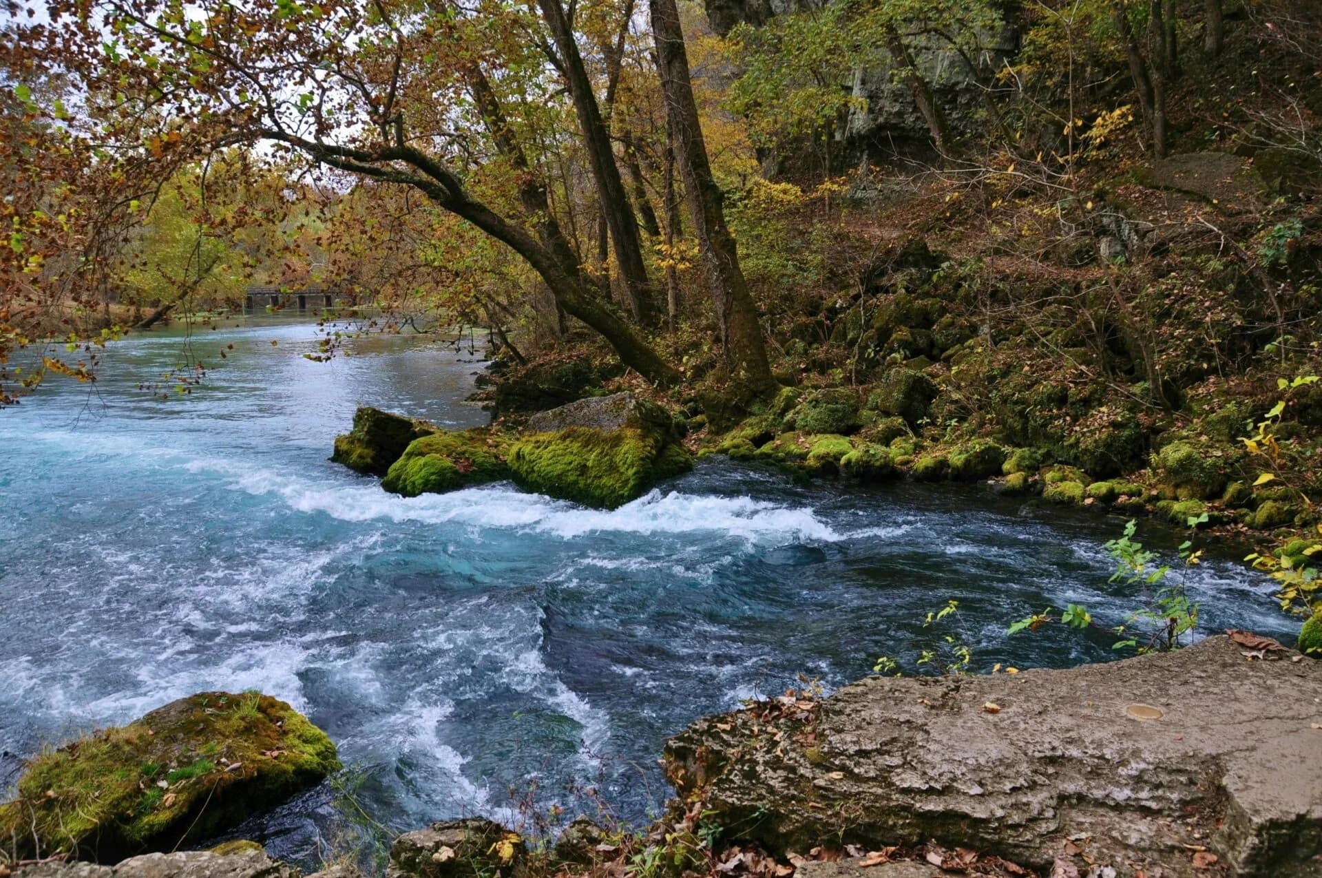 Big Spring rushing past mossy boulders in fall, south of Van Buren